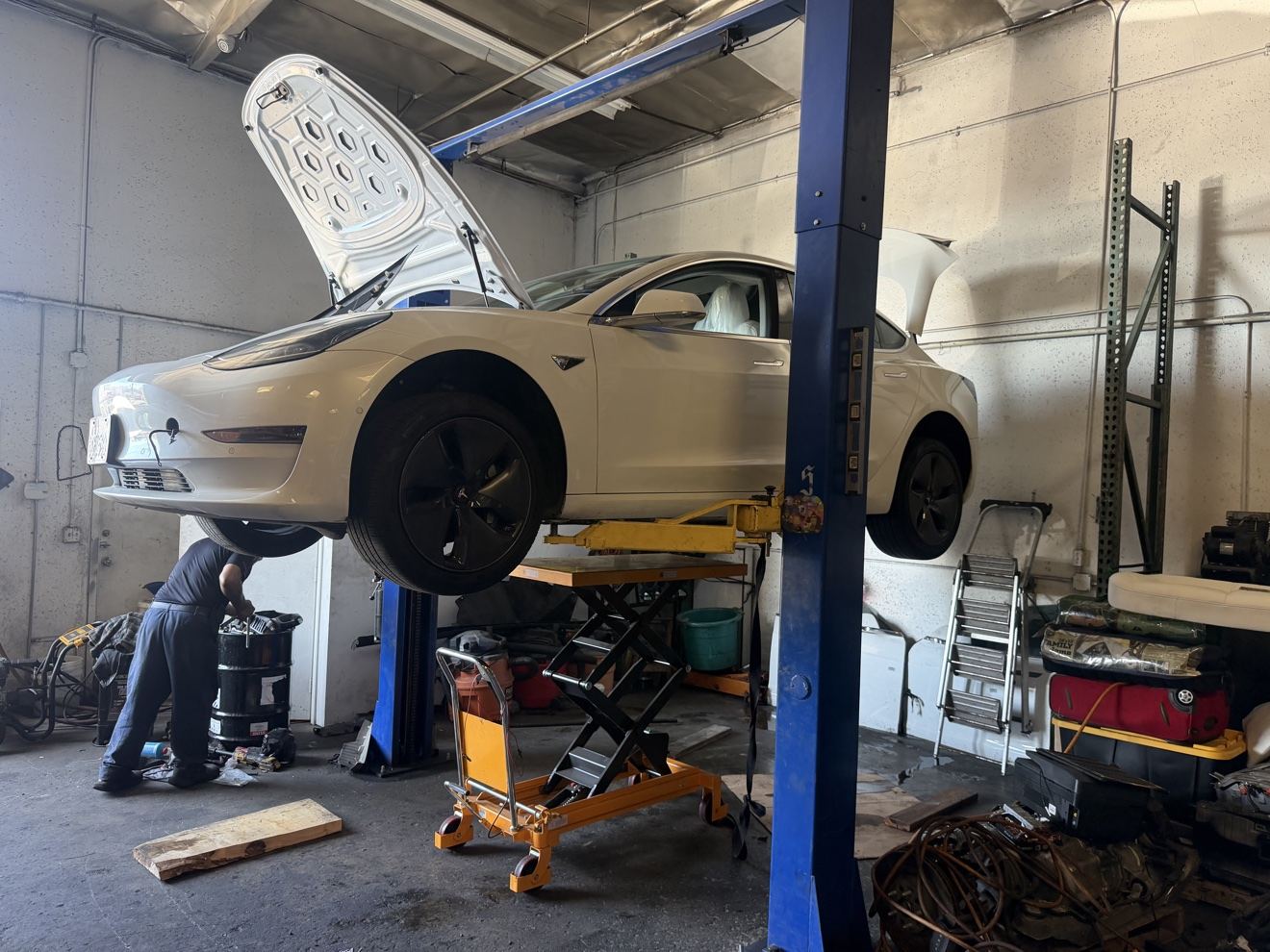 Tesla on the lift at Certified Hybrid in Fullerton during hybrid battery service